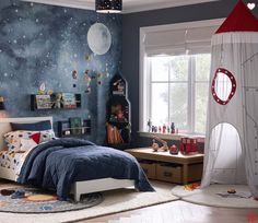 a child's bedroom decorated in blue and white with space themed wallpapers