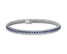 A row of delicate, deeply-blue sapphires, flanked by rows of shimmering diamonds, is set in 14k white gold to form a delicate bracelet that dazzles. Sapphire Tennis Bracelet With Prong Setting, White Gold Sapphire Tennis Bracelet For Wedding, Blue Diamond Bracelet With Brilliant Cut, Blue Brilliant Cut Diamond Bracelet, Sapphire Diamond Bracelet With Brilliant Cut, Blue Diamond Bracelet In Prong Setting, Brilliant Cut Sapphire Diamond Bracelet In Fine Jewelry Style, Blue Diamond Bracelet With Prong Setting For Anniversary, Blue Diamond Bracelet With Prong Setting