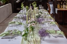 a long table is set with flowers and wine glasses