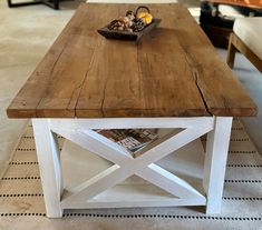 a wooden table sitting on top of a rug in a living room next to a couch