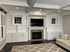 a living room with white furniture and a fireplace