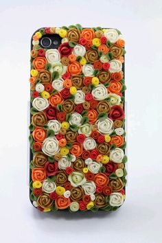 an iphone case made out of flowers on a white surface with green leaves and oranges