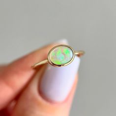 14K Yellow gold ring with Australian Crystal Opal Size: 7.25 Opal size: 8x6mm (0.5 ct) Metal: 14K yellow gold Band: 1mm Stones: Australian opal (natural untreated stone)   We offer complimentary sizing for most of our 14K gold rings, so please email us to inquire before placing an order. Yellow Gold Oval Opal Ring, Yellow Gold Ethiopian Opal Ring In Oval Cabochon Shape, Yellow Gold Ethiopian Opal Oval Cabochon Ring, Ethiopian Opal Oval Cabochon Ring In Yellow Gold, Yellow Gold Ethiopian Opal Ring In Oval Shape, Yellow Gold Opal Ring Oval Cabochon For Gift, Oval Opal Ring In Yellow Gold Stamped 14k, Yellow Gold Oval Solitaire Opal Ring, Oval Solitaire Opal Ring In Yellow Gold