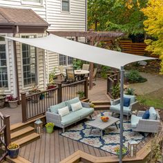 a deck with furniture and an awning over the seating area on top of it