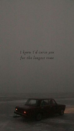 an old car sitting in the middle of a foggy field with a quote written on it