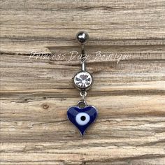 an evil eye belly ring with a blue heart