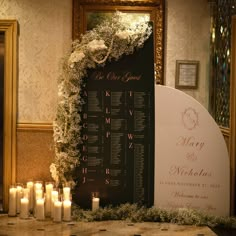 a wedding seating chart with candles and flowers