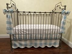 a baby crib with blue and white checkered sheets