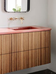 a bathroom with a sink, mirror and wooden cabinet