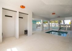 an empty swimming pool in the middle of a large room with white walls and floors