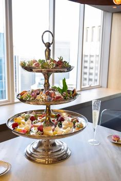 three tiered trays filled with food on top of a table