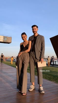 a man and woman are standing on a boardwalk