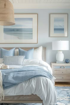 a bedroom with blue and white bedding, pictures on the wall and rugs