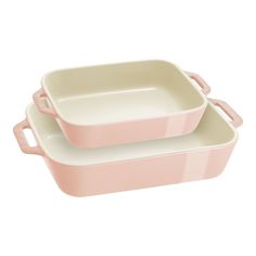 two pink casserole dishes sitting on top of each other