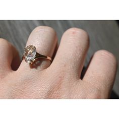 a person's hand with a ring on it and a diamond in the middle