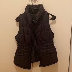 Never Worn Black Winter Vest With Pockets, Black Stretch Vest For Fall, Black Puffer Vest For Winter, Black Puffer Vest For Spring, Black Winter Vest For Cold Weather, Black Vest For Cold Weather And Winter, Casual Black Winter Vest, Fitted Black Outerwear With Pockets, Black Stretch Outerwear For Winter