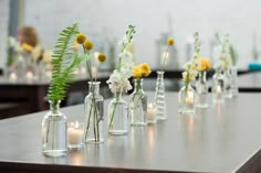 several vases filled with flowers and candles on a table