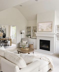 a living room filled with furniture and a fire place in the middle of an open floor plan