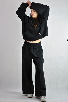 This is a very trendy pair of modern tracksuit pants. Very flattering, loose flared cut. Elasticated waist with inside drawstring. It has got a stitched crease for modern edgy look.  The fabric is high quality, made in Poland. Black. Here is a matching hoodie: https://www.etsy.com/listing/1682696822/black-tracksuit-top-cotton-hoodie?click_key=d87269dc13da5a56dcd7e05674c00b018ff83094%3A1682696822&click_sum=52db79b8&ref=shop_home_active_1&frs=1&sts=1 Our model is size S/M, wearing size M tracksuit Sporty Cotton Wide Leg Pants With Loosely Fitted Hips, Sporty Cotton Wide Leg Pants With Loose Fit, Stretch Wide Leg Parachute Pants For Fall, Fall Stretch Wide Leg Parachute Pants, Cotton Wide Leg Pants For Streetwear Athleisure, Flared Cotton Loungewear Bottoms, Cotton Wide-leg Athleisure Pants, Sporty Cotton Wide Leg Pants, Wide Leg Stretch Sweatpants For Streetwear