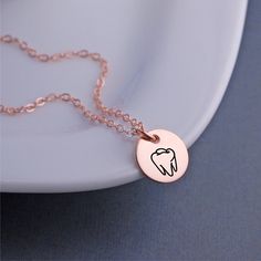 A 12mm (1/2 inch) disc is engraved with a tooth outline. Metals available include 14k rose gold filled, 14k gold filled and stainless steel pendant with sterling silver filled chain. Lengths available include 16, 18 or 20 inches. **ALL charms are optional! (shown with 1 added initial charm). Choose from initials, Swarovski crystal birthstones or other symbols. Rose Gold Sterling Silver Charm Necklace, Rose Gold Charm Necklaces With Round Pendant, Minimalist Rose Gold Charm Necklace, Hypoallergenic Rose Gold Jewelry For Personalized Gifts, Minimalist Rose Gold Hand Stamped Charm Necklaces, Rose Gold Round Pendant Charm Necklace For Personalized Gift, Minimalist Hand Stamped Rose Gold Charm Necklace, Minimalist Rose Gold Hand Stamped Charm Necklace, Personalized Rose Gold Round Pendant Charm Necklace