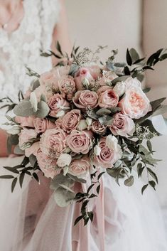 a bridal holding a bouquet of pink roses