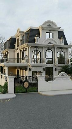 a large white house with lots of windows and balconies