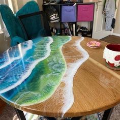 a wooden table topped with an ocean wave painted on top of it's surface