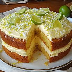 a cake with limes and coconut on top is cut in half to show the inside