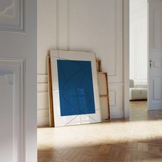 an empty room with a blue painting on the floor