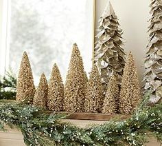 some christmas trees are sitting on a mantle