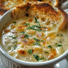 a bowl of soup with bread on the side