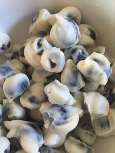 a white bowl filled with dumplings sitting on top of a table