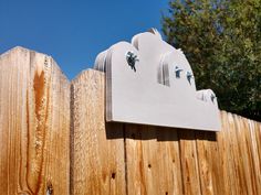 a wooden fence with two sculptures on it