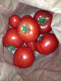 a bunch of tomatoes in a brown paper bag