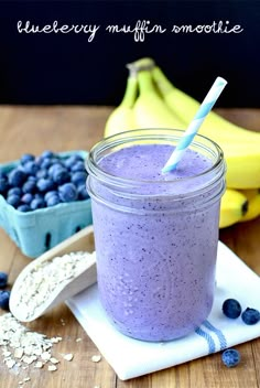 a blueberry muffin smoothie in a mason jar next to bananas and blueberries