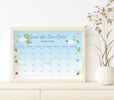 a white vase sitting on top of a dresser next to a calendar