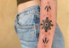 a woman with a tattoo on her arm that has flowers and dots all over it