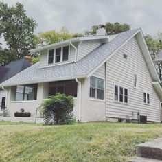 a white house sitting on top of a lush green field