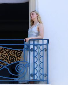 a woman standing on a balcony looking out the window