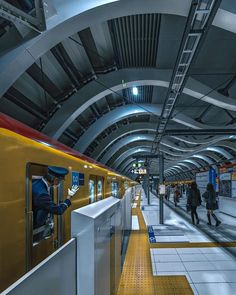 a subway station with people standing on the platform