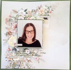 a woman with glasses is smiling in front of a floral frame that has flowers on it