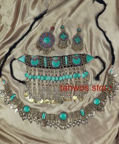 We call this the "Baran Set" - It translates to rain.  This is a traditional jewelry set originated and inspired by classic Afghan fashion. This set contains 5pcs: Necklace, Pair of earrings, belt and a Matika (Headpiece).  Colors: Silver and Blue  Necklace: 6.5 " drop Earrings:  4 " Matika: 5 " Belt: 49 " Please note: As this piece is completely handmade, minor discrepancies may be present. These imperfections contribute to making it a unique and one-of-a-kind piece.  Care Instructions: Clean t Balochi Doch Jewelry, Traditional Turquoise Jewelry Sets For Wedding, Adjustable Turquoise Bohemian Jewelry Sets, Bohemian Jewelry For Festivals With Stone Work, Bohemian Festival Jewelry With Stone Work, Bohemian Jewelry With Stone Work For Festivals, Adjustable Jeweled Festival Jewelry, Bohemian Ceremonial Jewelry With Stone Work, Handmade Turquoise Jewelry For Festive Occasions