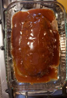 a meatloaf in a glass casserole dish with sauce on the side