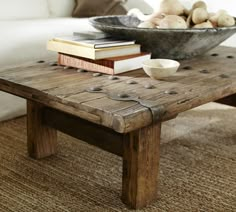 a coffee table with some books on it and a bowl of potatoes in the background