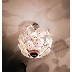 a light fixture with flowers on it in a room