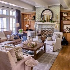 a living room filled with furniture and a fire place in front of a mirror on the wall