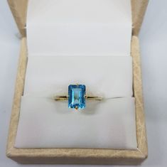 14k solid yellow gold natural emerald cut rectangular shaped blue topaz semi precious gemstone ring. 1. The weight of natural blue topaz gemstone used in the ring =1.40 cts. 2. The weight of 14k solid yellow gold used in the ring =1.150 grms. 3. The topaz is the birthstone for the people born in the month of November. 4. The design of the ring is very nice and beautiful. 5. I have used all my skills and experience to manufacture this ring as beautiful as I can and I do hope that my work will be Rectangular Yellow Gold Ring With Gemstone, Emerald Cut Topaz Ring In Yellow Gold, Emerald Cut Yellow Gold Topaz Ring, Elegant Yellow Gold Rectangular Topaz Ring, Rectangular 14k Gold Emerald Ring As Gift, 14k Gold Rectangular Emerald Ring Gift, 14k Yellow Gold Emerald Ring With Rectangular Stone, Gold Emerald Cut Topaz Ring, Blue Rectangular Topaz Jewelry