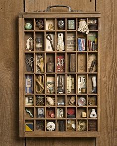 a wooden box filled with lots of different types of items on top of a wall