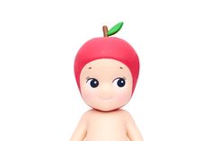 a small doll with an apple on top of it's head and eyes, standing in front of a white background