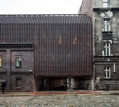 an old building that has been made out of bricks and is in the middle of a cobblestone street